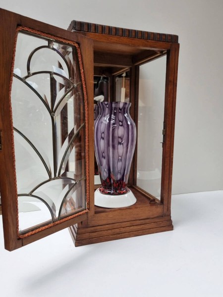 Oak Art Deco cabinet showcasing a purple glass vase against the mirrored back